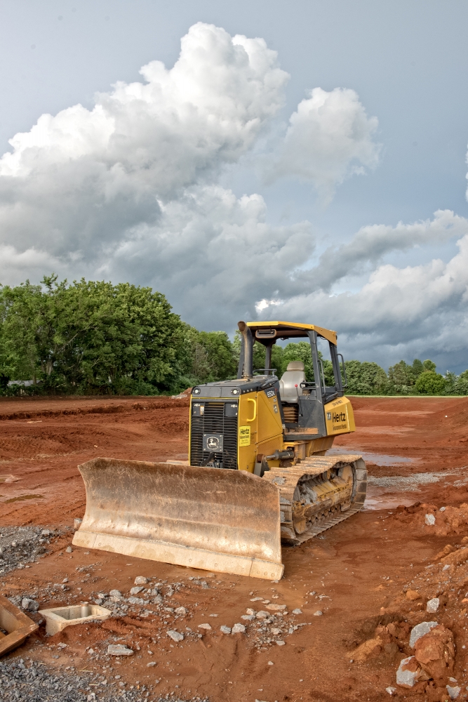 grader construction equipment at building site dark clouds photo