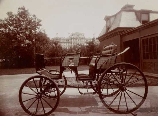 Horse drawn surrey outside the White House stables with view of 