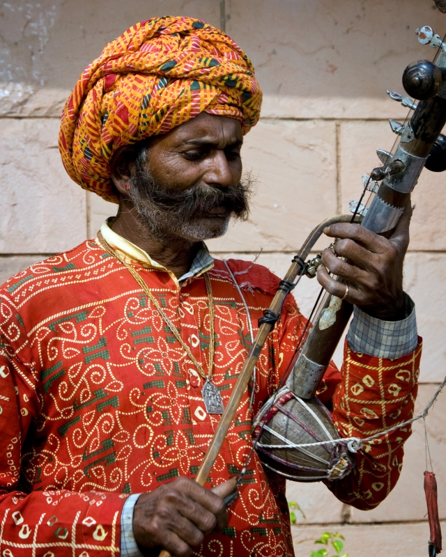 man playing muscial instrument india
