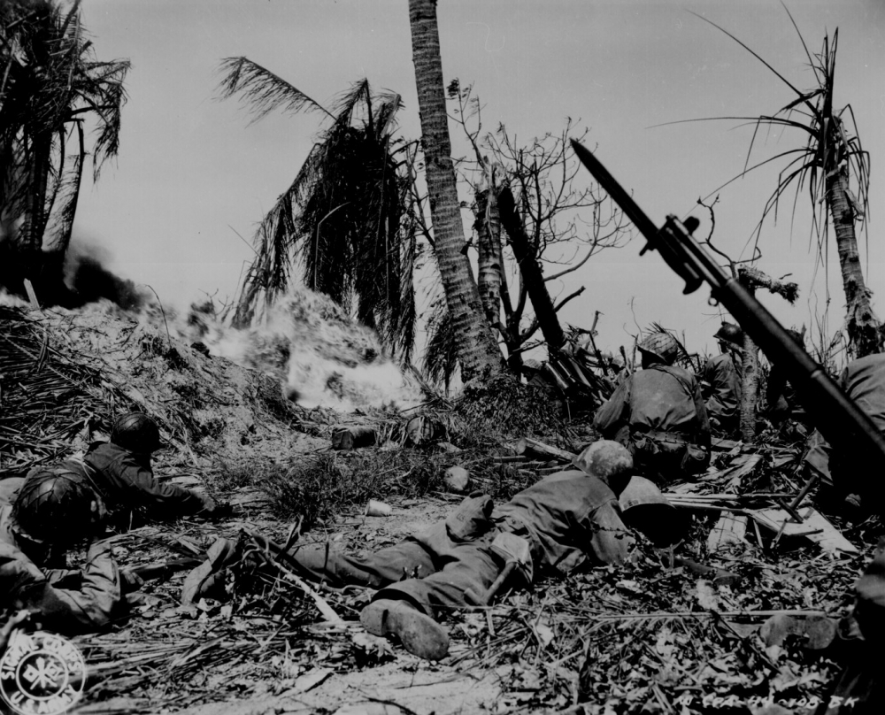 Men of the 7th Division using flame throwers to smoke out Japanese