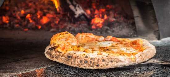 Pizzas cooks in the wood fire oven