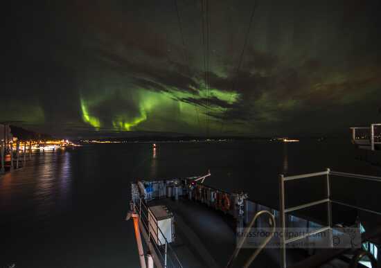 ship moored under northern lights in norway