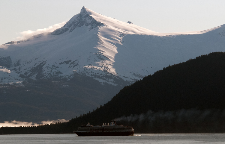 ship sailing in the waters off alaska with snow covered mountain