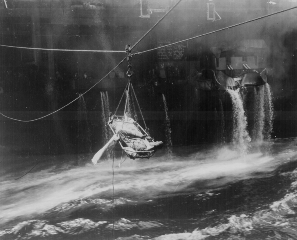 Transfer of wounded from USS BUNKER HILL to USS WILKES BARRE, who were injured during fire aboard carrier following Jap suicide dive bombing attack off Okinawa.