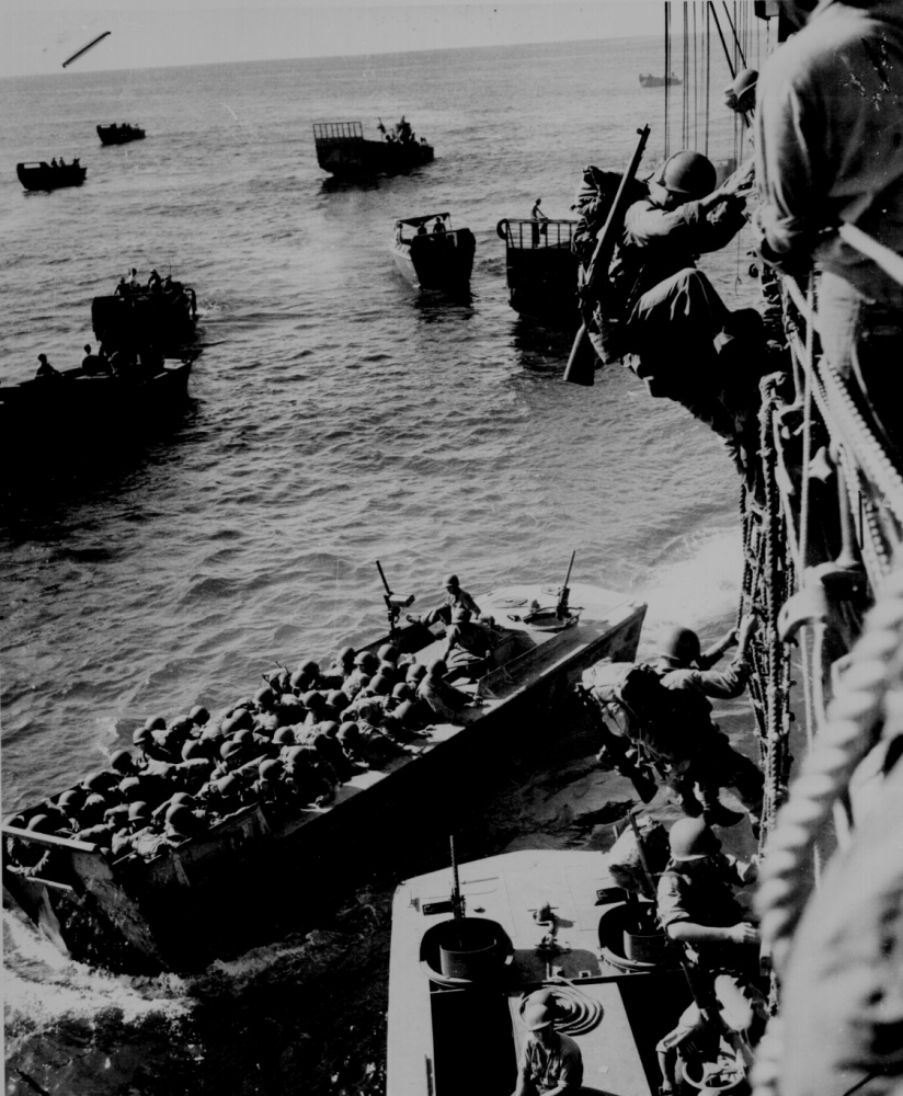 U S troops go over the side of a Coast Guard manned combat transpor