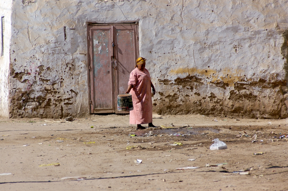 woman empties water from bucket in aswan egypt