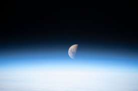 a first quarter moon above the earths limb