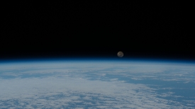 a waning gibbous moon is pictured just above the earths horizon