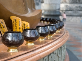 Alms bowls encircle the base of the Kuan Yin pedestal penang
