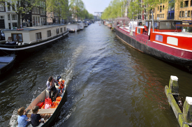 Amsterdams famous canals with a tourist boat during spring