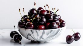 bowl of ripe and juicy black cherries in a gray white bowl