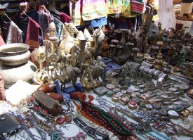Clothing jewelry sculptures and handicrafts on display at a baza