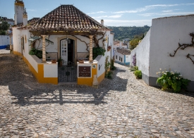 corner building alongg cobble stone street obidos portugal