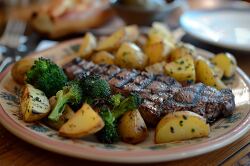 Declicious plate with grilled charred steak  roasted potatoes