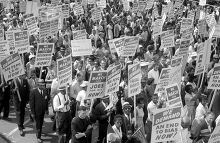Demonstrators marching in the street holding signs