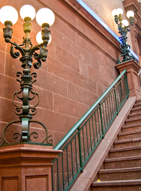 depicts an ornate staircase with decorative lamps showcasing int