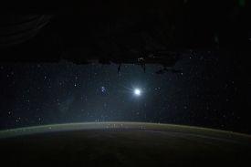 earths atmospheric glow the moon and a starry orbital nighttime 