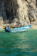 empty small boat along the rocky coast of cabo
