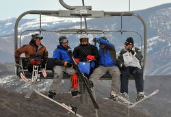 group of adaptive skiers ride a chairlift together