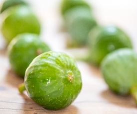 Macro Closeup Rows Of Green Figs On Wood Background 