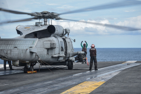 Maritime Strike Squadron 77 signals an MH-60R Sea Hawk on the fl