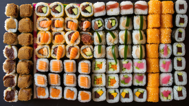 olorful assortment of sushi rolls neatly arranged in rows