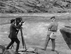 photographer with man fishing 1920