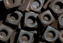 pile of square metal nuts with a weathered appearance
