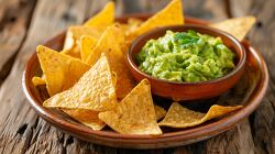 plate of nacho chips with a bowl of guacamole dip