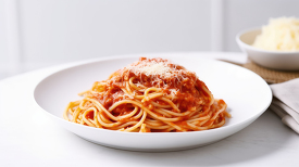 plate of spaghetti with rich marinara sauce with grated cheese o