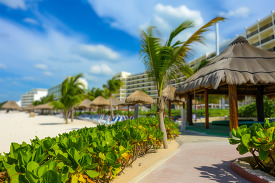 relaxing Cancun beach with hotels and palm covered cabanas