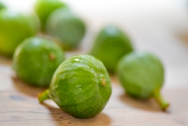 Rows Of Green Figs On Wood Background 