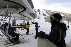 Skiers prepare to disembark from a chairlift at a mountain resor