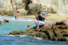 snorkeler prepares to jump in the blue water of cabo san lucas