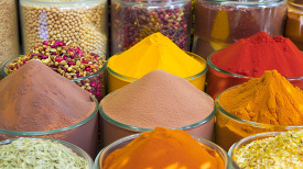 Spice market display with an array of colored powders and seeds