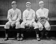 three baseball players sitting on the bench
