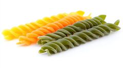 trio of raw fusilli pasta in green orange and yellow hues