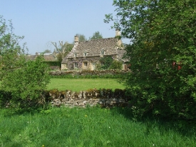 Typical Cotswolds hills cottage and dry stone walls