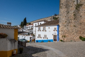 white washed building cobble stone street obidos portugal