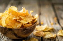 wooden bowl overflowing with potato chips