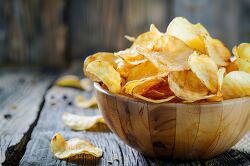 Wooden bowl with golden potato chips