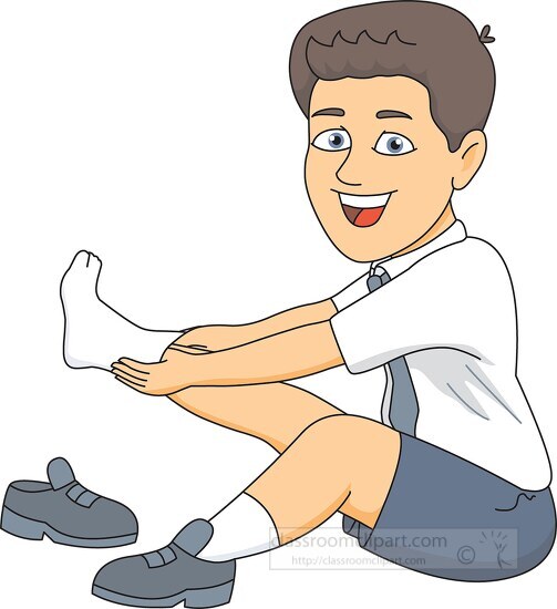 boy sitting down putting on socks shoes