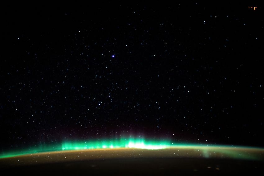 an aurora blankets the earth beneath a celestial night sky 22