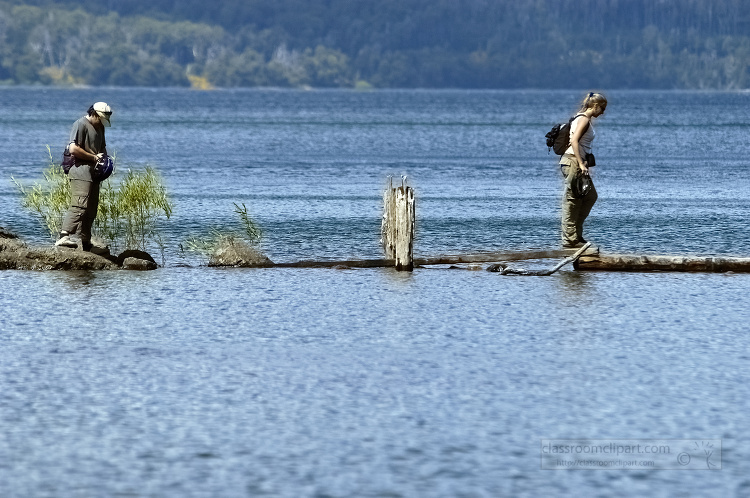 couple walking on rocks across lake in argentina