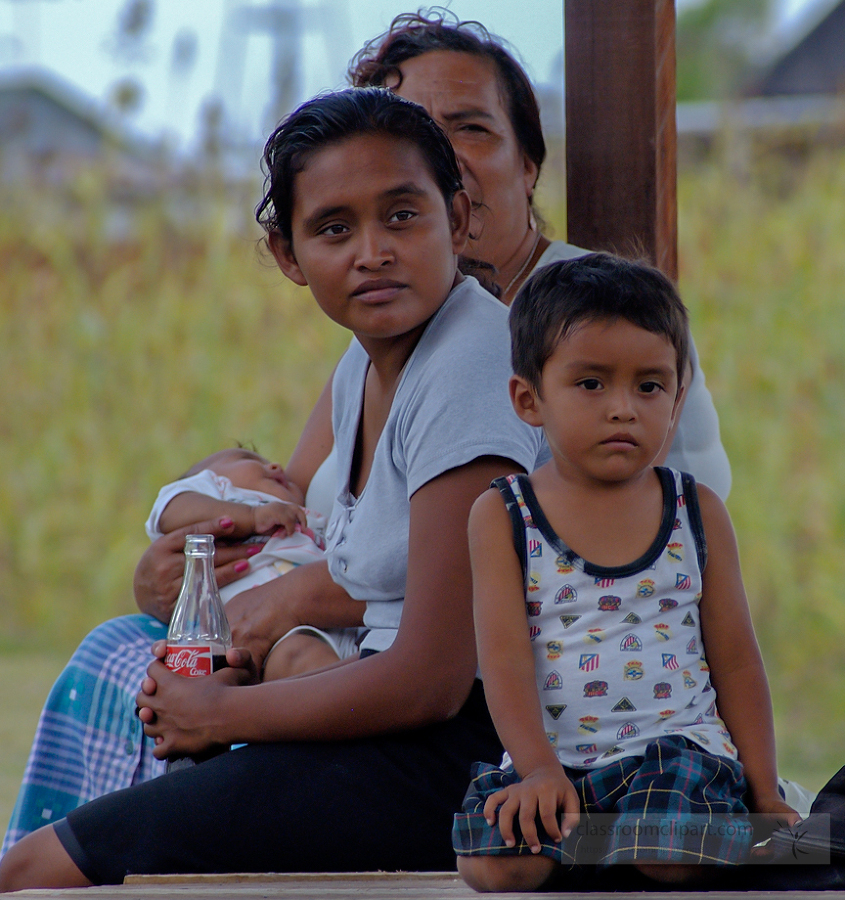 Family sitting along river bank in Belize