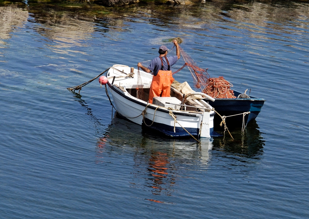 Man Fishing in a Small Boat