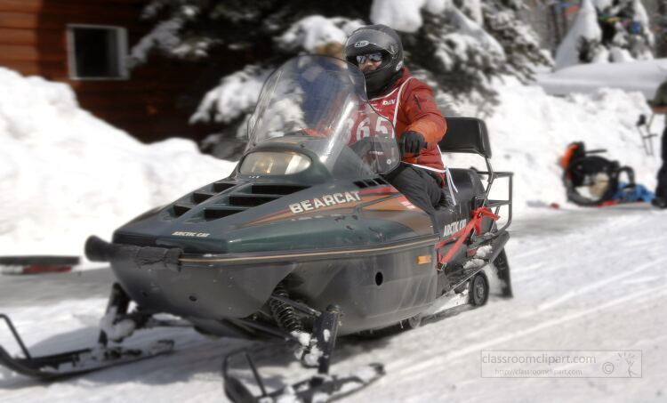 person rides a Bearcat snowmobile on a snowy trail