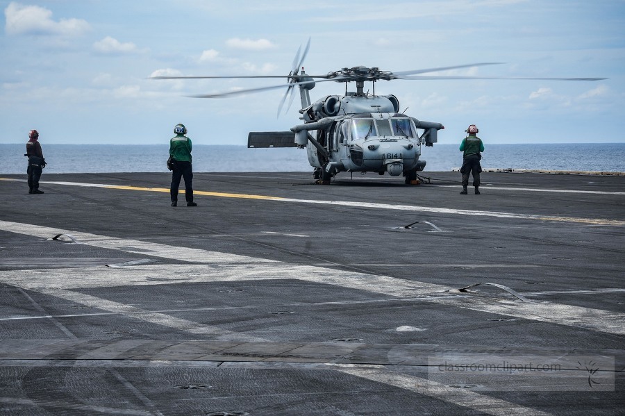 sailors prepare an MH-60S Sea Hawk for take-off from the flight 