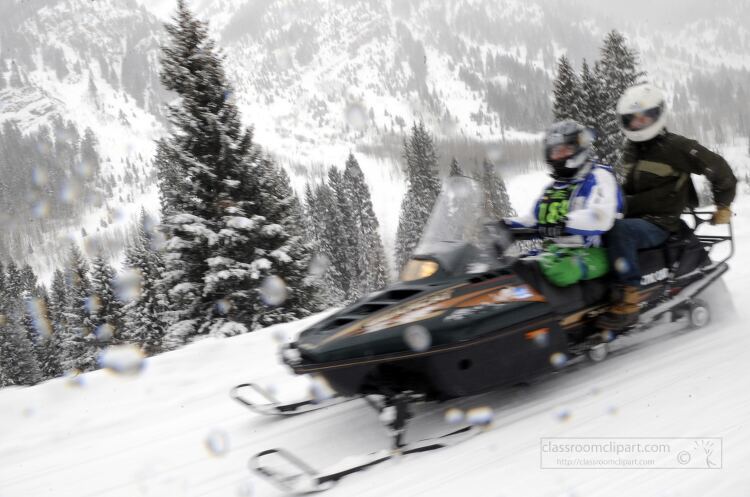 snowmobile speeding down a snowy slope