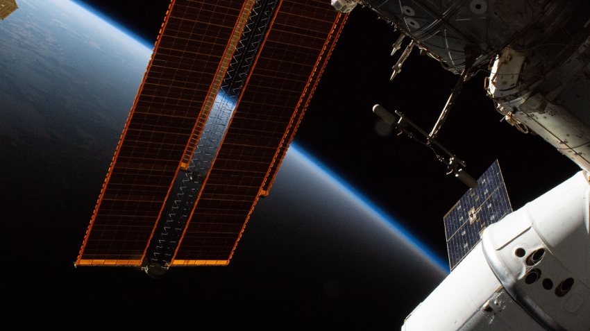the space station flies into an orbital sunset